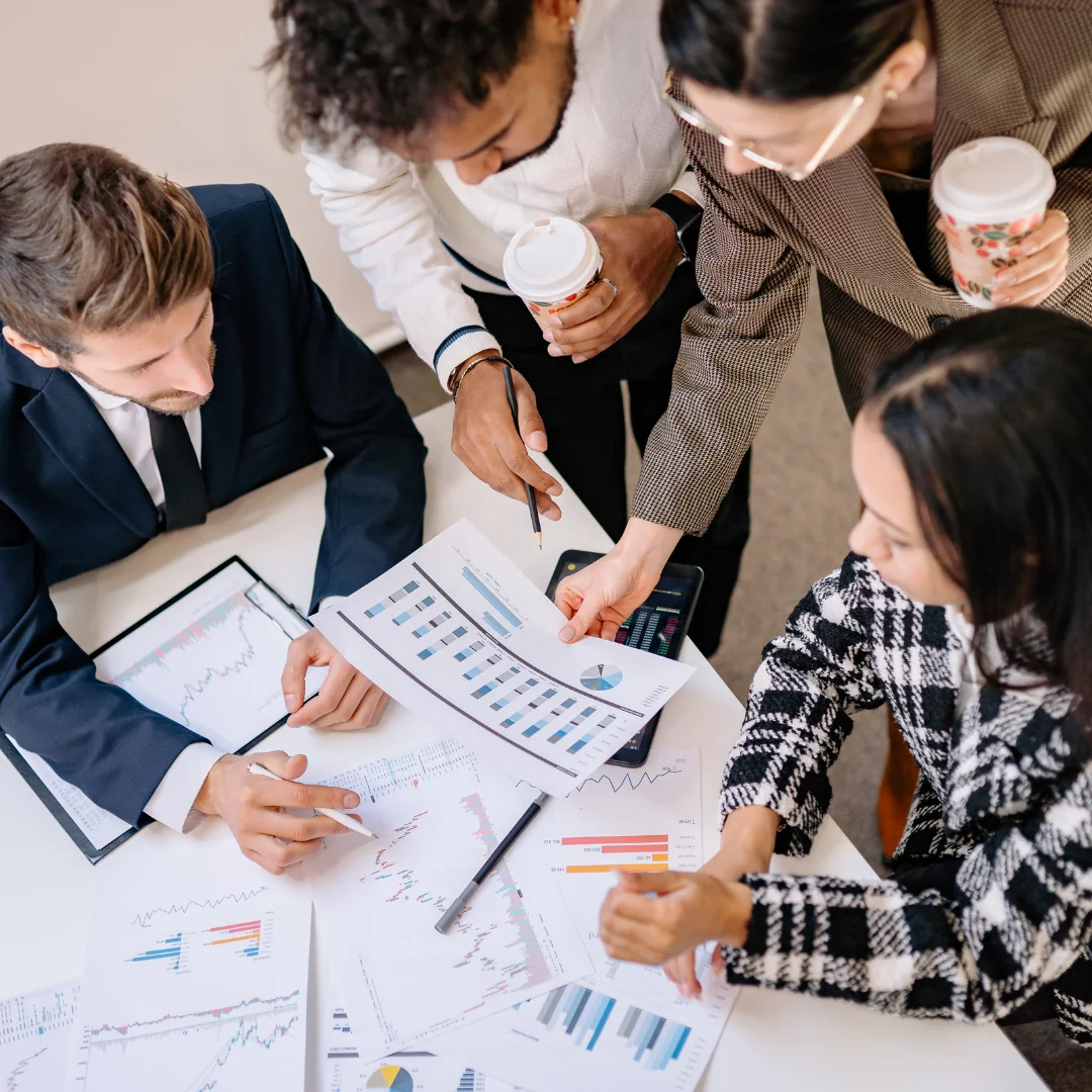 Business team reviewing performance charts and reports together around a table